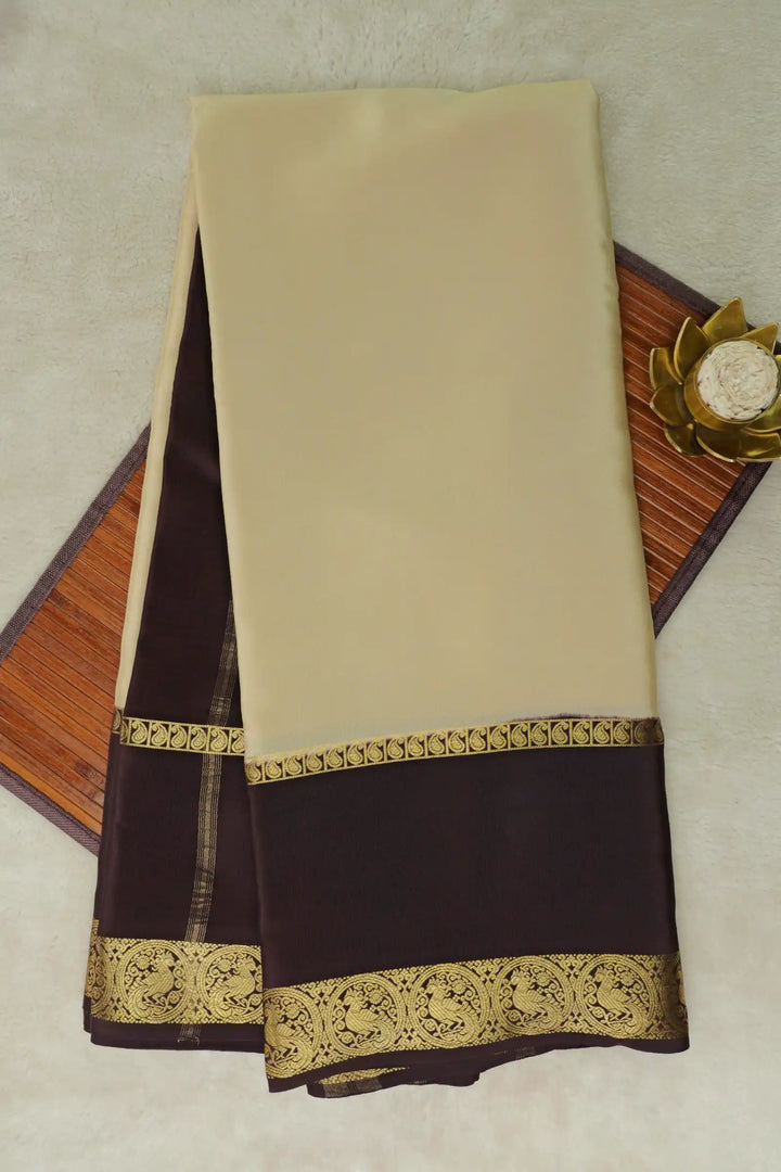 Beige and brown mysore silk saree with a peacock border
