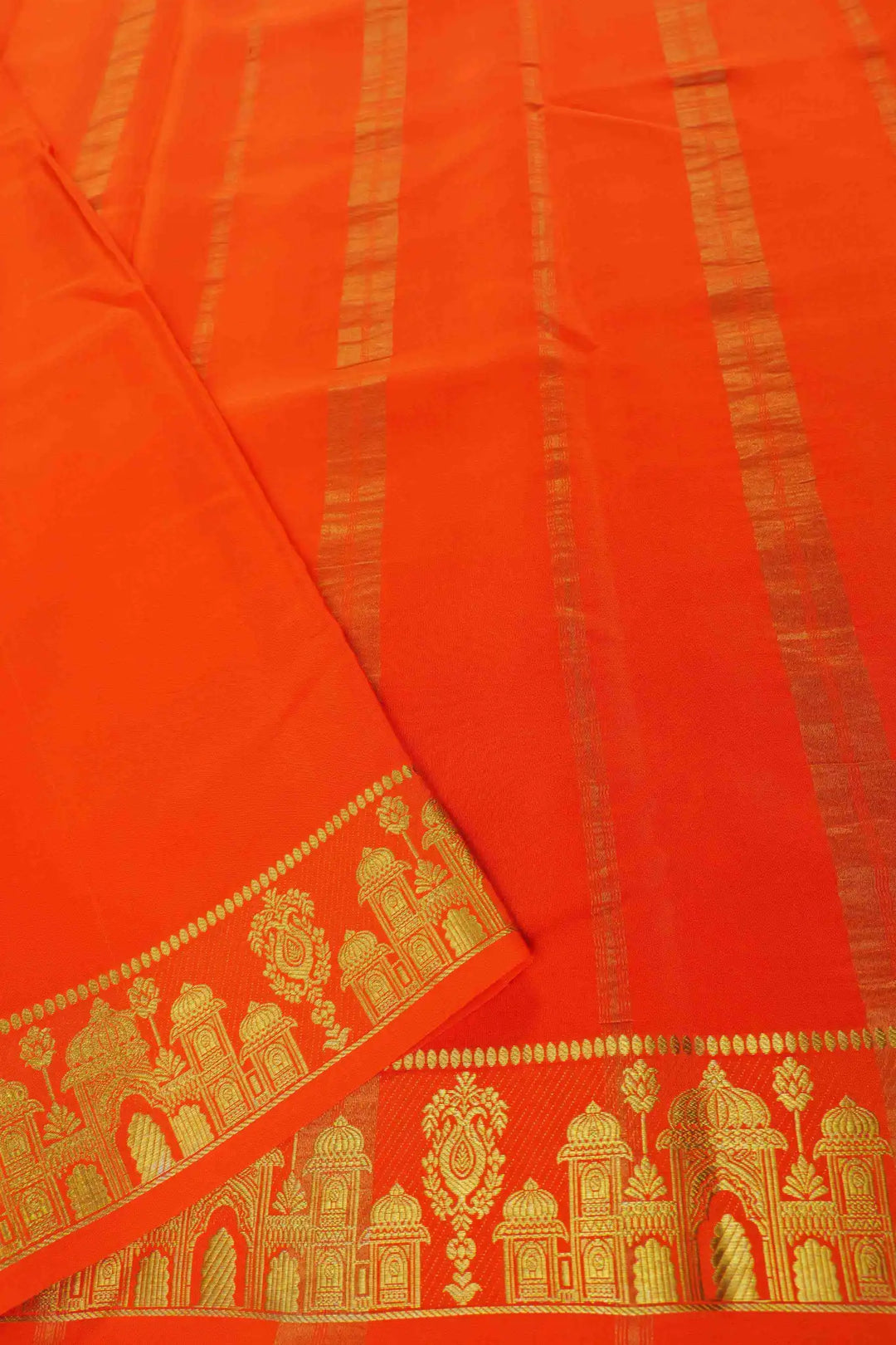 Maroon silk saree featuring gold patterns and an orange temple-style border