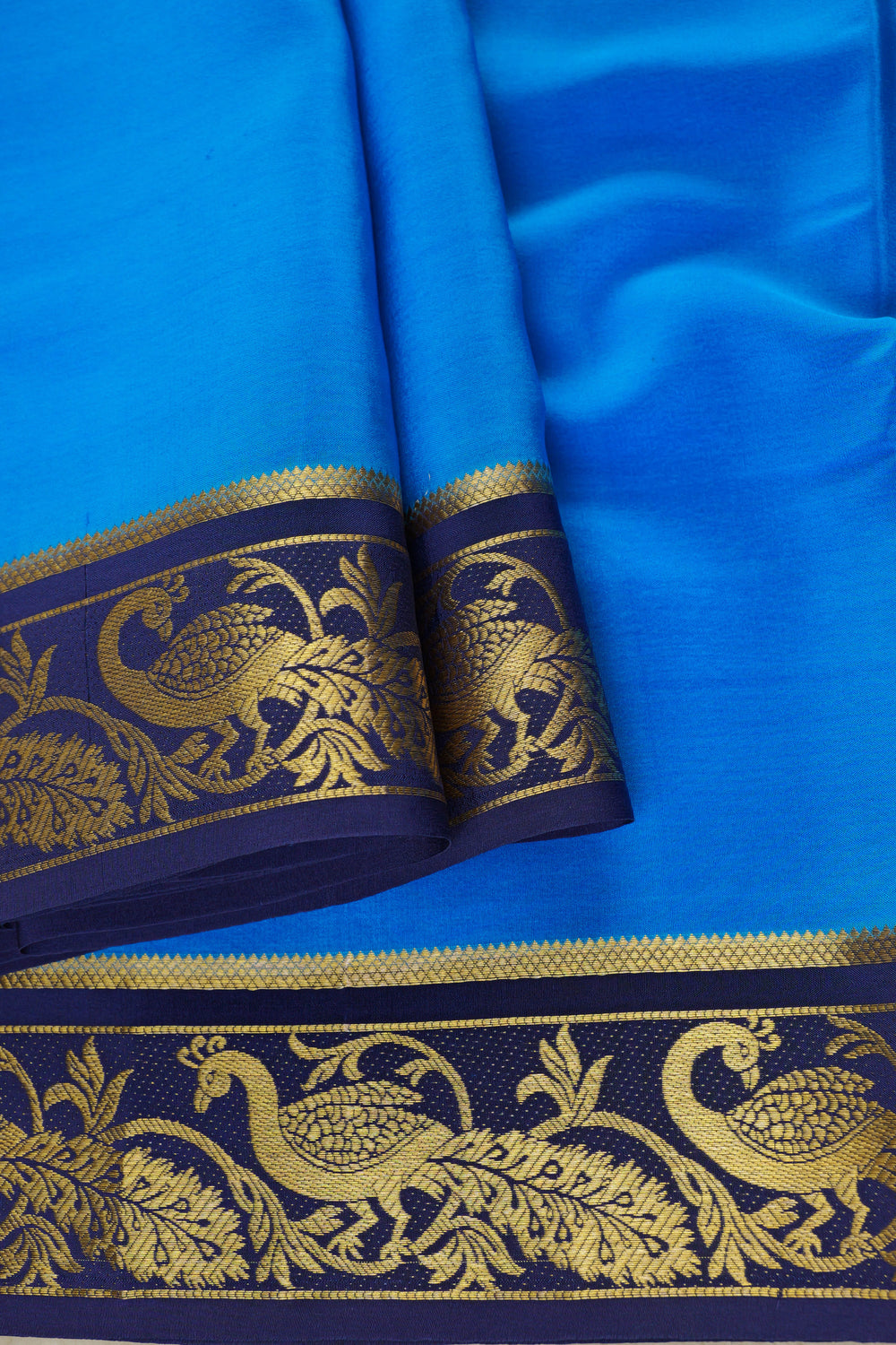 Mysore silk saree in sky blue with an intricate golden peacock border on navy blue