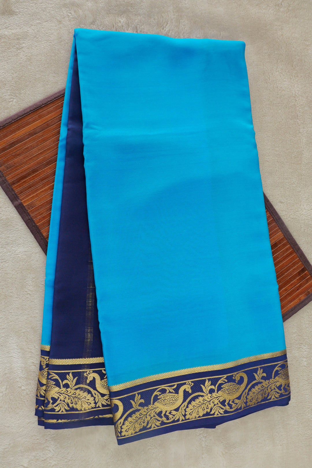 Pure Mysore silk saree in sky blue with a contrasting navy blue border featuring golden peacock zari motifs.