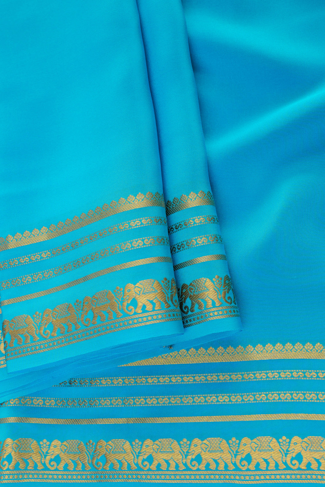Pure turquoise blue Mysore silk saree featuring gold elephant border