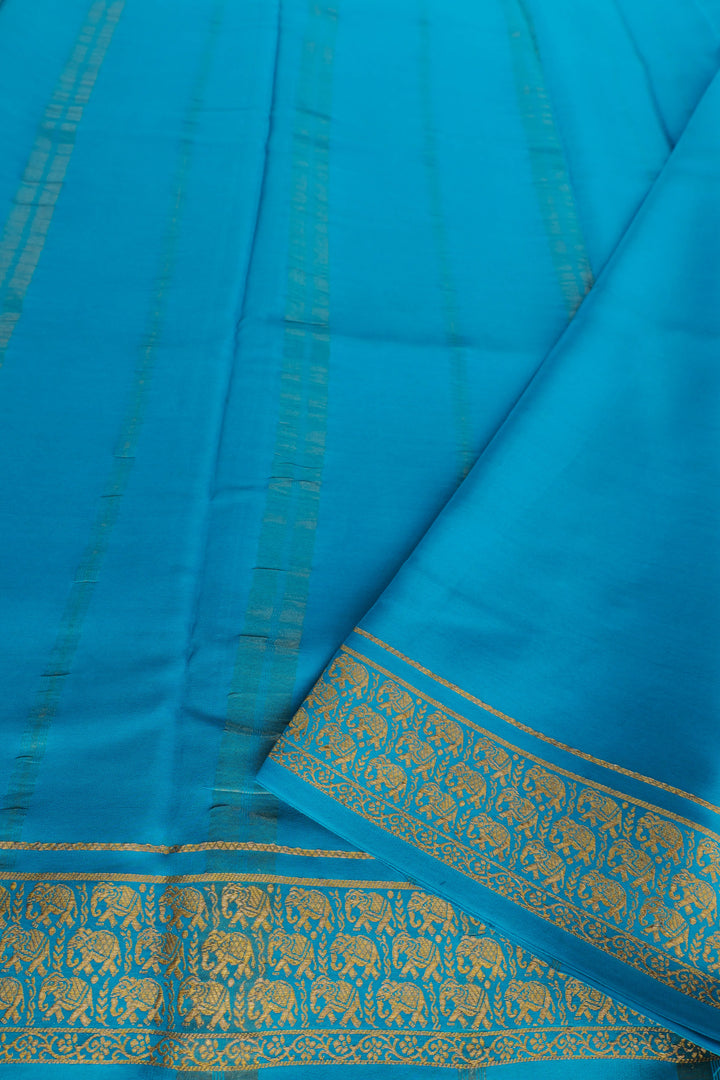 Purple silk saree with vibrant blue border and golden elephant design