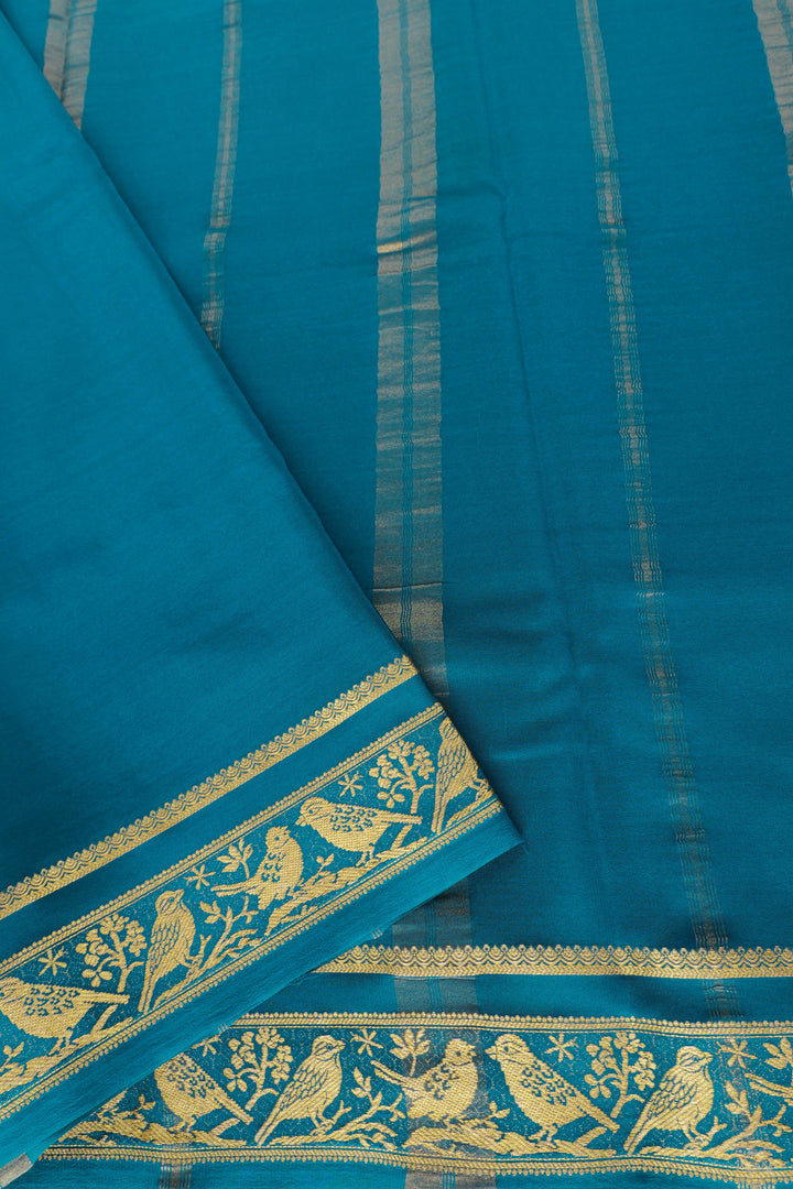 Teal green silk saree with ornate gold pallu and border patterns