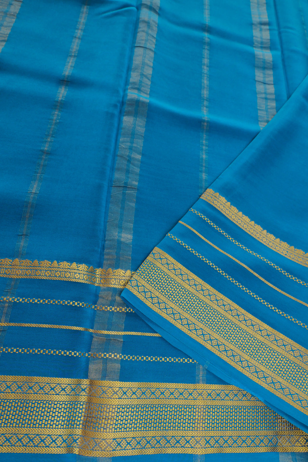 blue Mysore silk saree with an elegant gold border and a striped pallu.