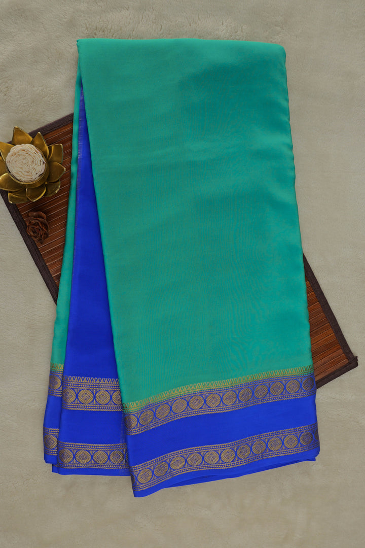 green saree with contrasting blue and gold