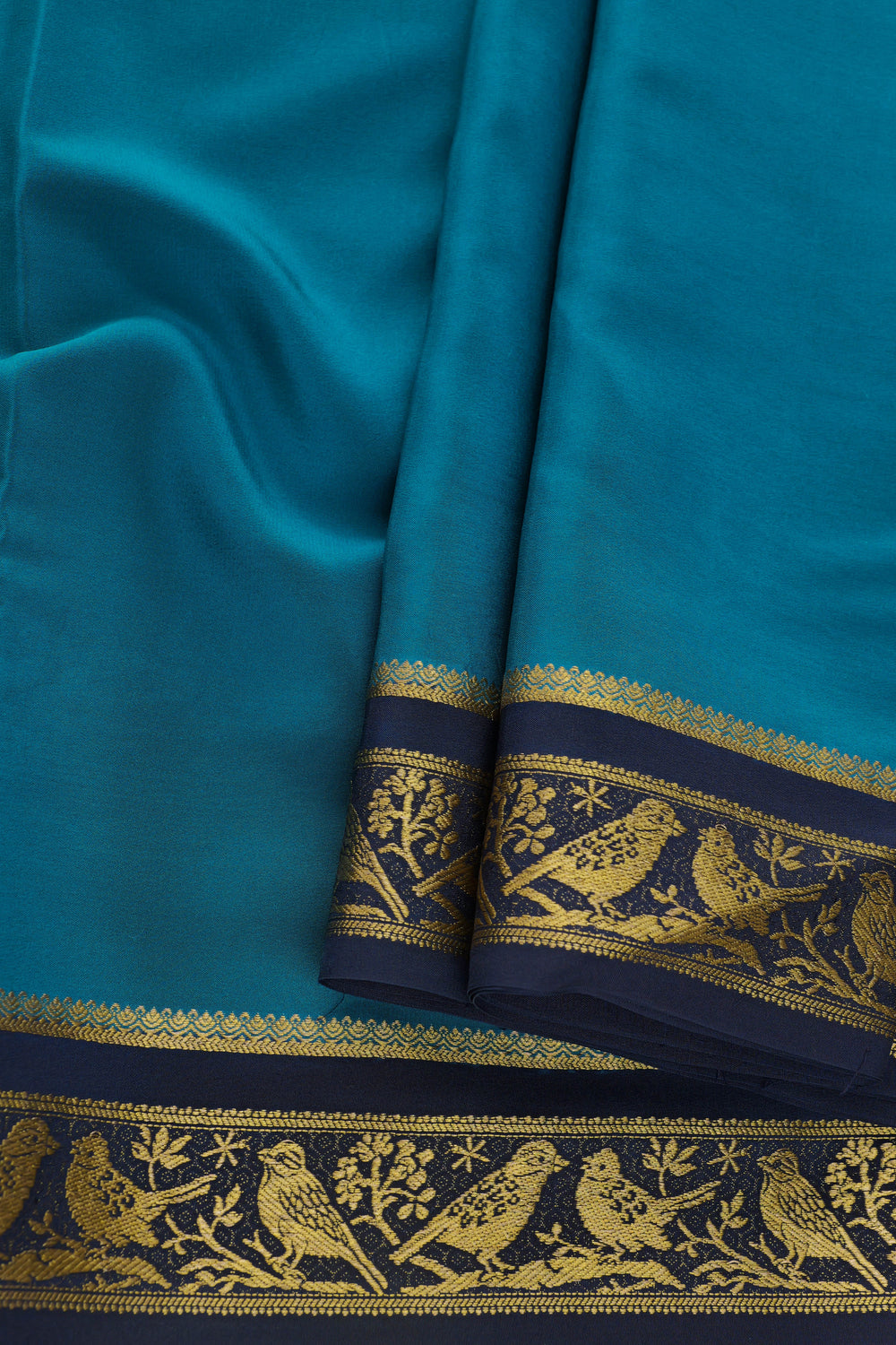 teal silk saree with contrasting navy border and gold zari work
